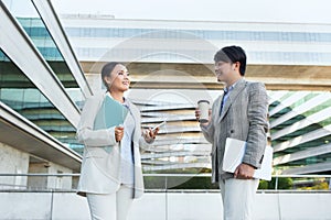 Two Business People Talking in Front of an Office Building