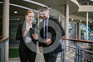 Two business people talking and using digital tablet outdoor. Communication concept