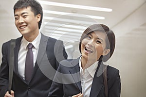 Two Business People Walking Together, Smiling and Laughing, Indoors