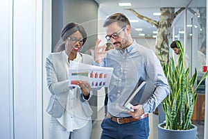 Two business people working together with documents during meeting in office