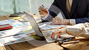 Two of business people working together in the meeting room office with laptop and paper charts, discussing and planning concept