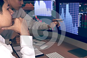 Two business stock brokers stress and looking at monitors displaying financial information