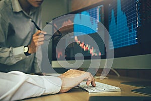 Two business stock brokers stress and looking at monitors displaying financial information