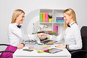 Two business women closing the deal with handshake