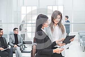 Two business women discussing business documents in the office