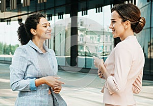 Two business women having a casual meeting or discussion in the city.