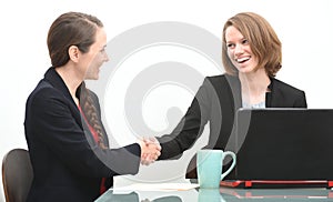 Two business women in interview or negotiation shaking hands