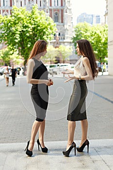 Two business women are negotiating in the background of the city