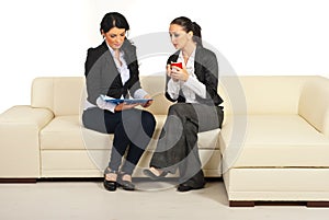 Two business women reading papers
