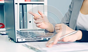 Two business women sitting together and working on laptop. Executives meeting in a office lobby. Woman pointing at