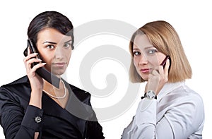 Two business women talking on mobile phone