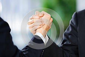 Two businessman grasp each other hand photo