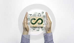 Two businessman hands protect infinity symbol with economy and ecology icon such as carbon reduction , recycle , solar cell ,