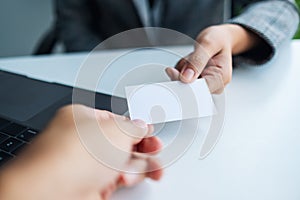 Two businessman holding and exchanging empty business card in officeTwo businessman holding and exchanging empty business card