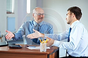 Two businessman with laptop discuss something