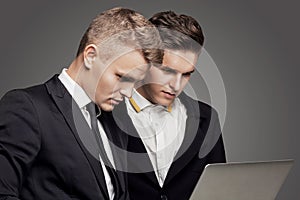 Two businessman looking at laptop