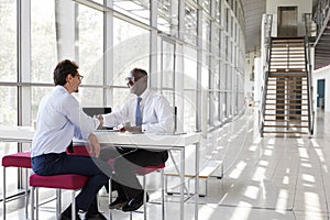 Two businessman shake hands during a meeting