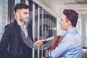 Two businessman standing and discuss a work or project strategy. Colleague talking and asking for the work opinion