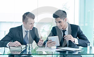 Two businessman using tablet in meeting