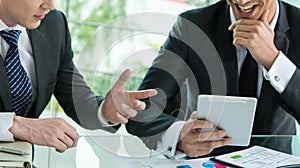 Two businessman using tablet in meeting