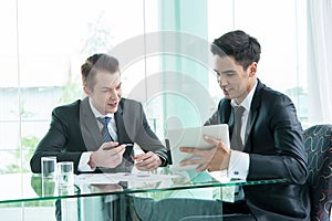 Two businessman using tablet during meeting