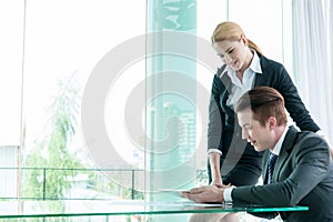 Two businessman using tablet during meeting