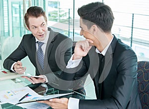 Two businessman using tablet during meeting