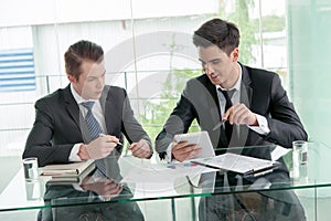Two businessman using tablet during meeting