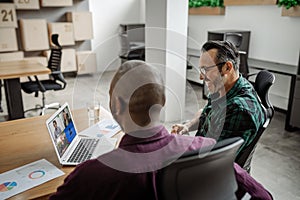 Two businessman video calling a colleague working remotely from home