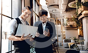 Two Businessman Working Together on Computer Laptop in Creative Workplace. Happy Business People