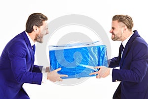 Two businessmen with aggressive expression hold box in hands