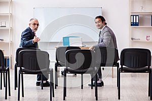 Two businessmen in the classroom in pandemic concept