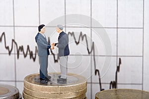 Two businessmen on coins