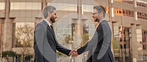 two businessmen deal with handshake. two businessmen deal with handshake outdoor.