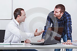 Two businessmen discuss at meeting in office