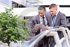 Two Businessmen Discussing Document Outside Office