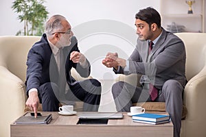 Two businessmen discussing project at workplace