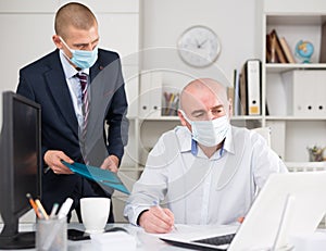 Two businessmen in fase masks discussing new ideas