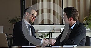 Two businessmen finish negotiations make deal shake hands express respect