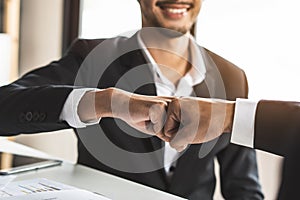 Two businessmen giving fist bump after project successful