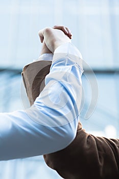 Two businessmen grasping hands together