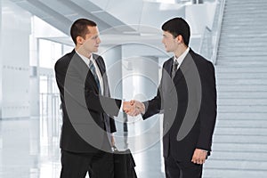 Two businessmen greet in business centre collage