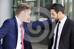 Two businessmen greeting each other outside