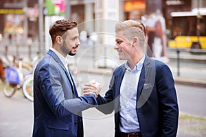 Two businessmen greeting each other in the street