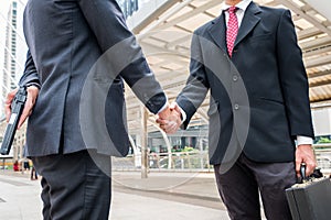 Two businessmen handshaking are dishonest and cheat with holding