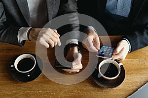 Two businessmen having a conversation using a smartphone