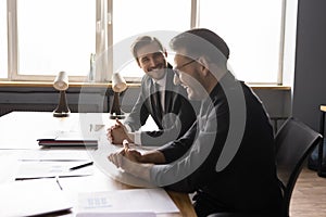 Two businessmen having fun, enjoying informal conversation at meeting