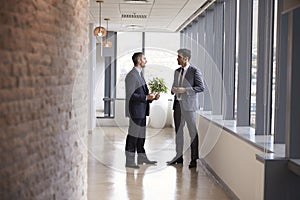 Two Businessmen Having Informal Meeting In Office Corridor photo