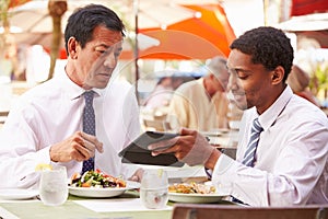 Two Businessmen Having Meeting In Outdoor Restaurant