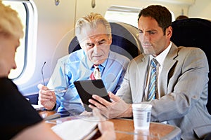 Two Businessmen Having Meeting On Train